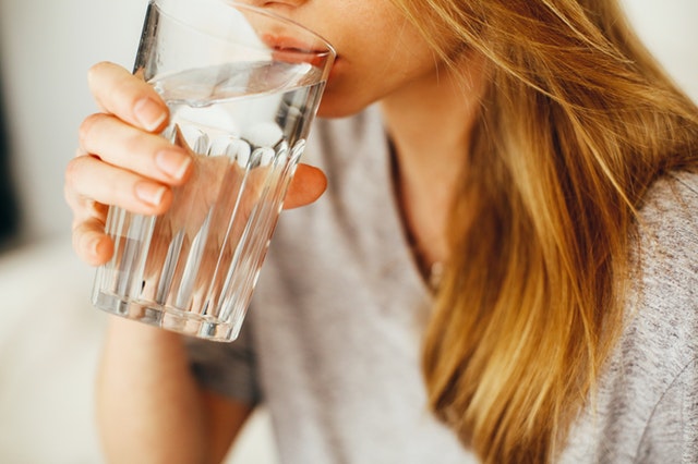Žena pije vodu so skleneného pohára